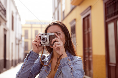 Young girl taking a picture in a narrow street