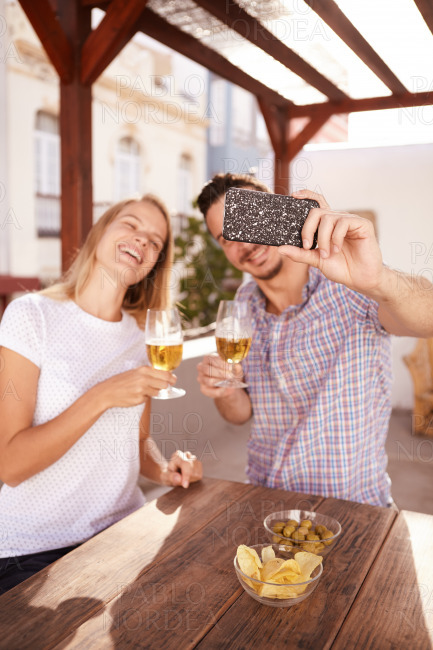 Couple taking selfie with their drinks