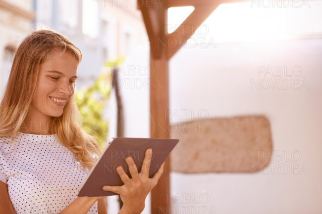 Cute blond smiling and using a touchpad