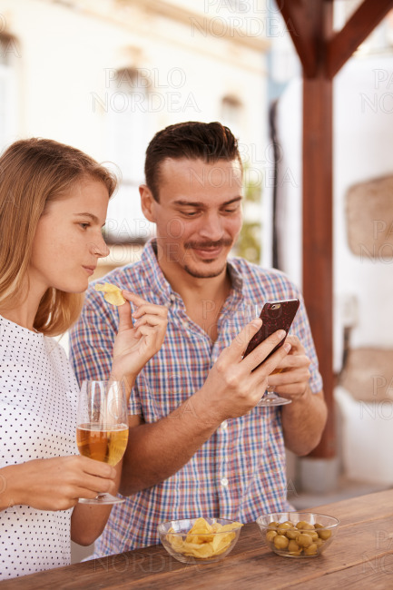 Dating couple with cellphone and beers