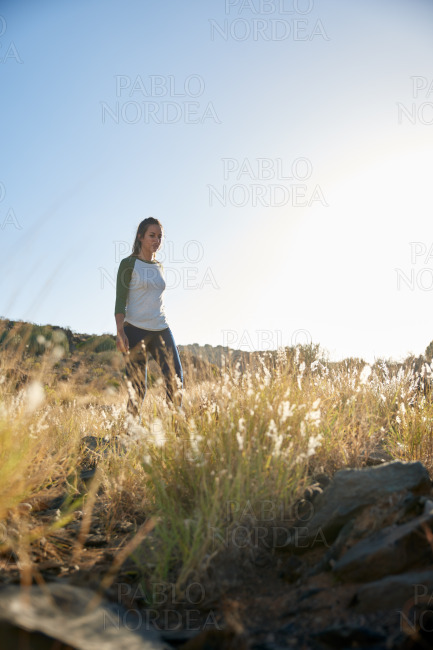 Girl standing on hill in sunlight
