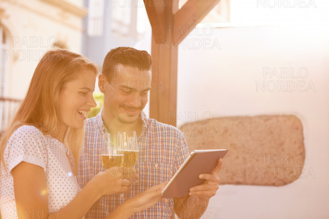 Goodlooking couple with touchpad and beers
