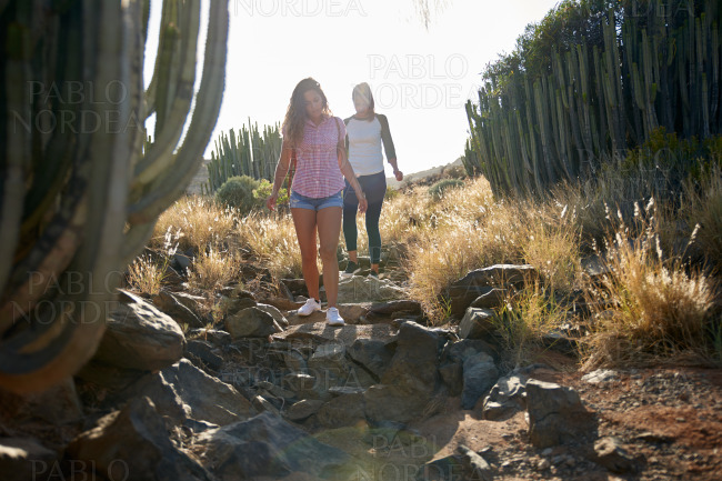 Healthy girls climbing down rocky path