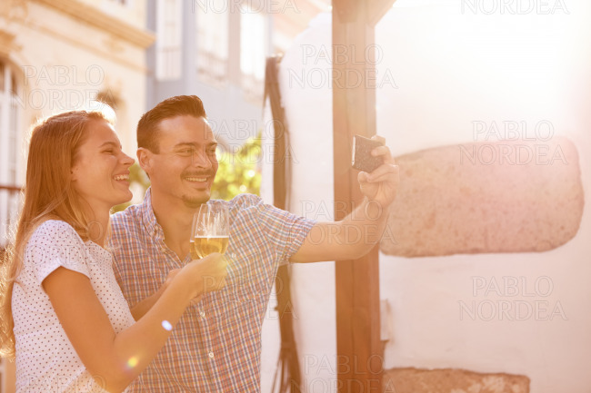 Laughing couple with beers taking selfie