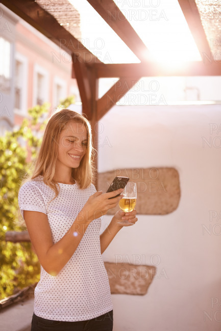 Lovely smiling blond girl looking at cellphone