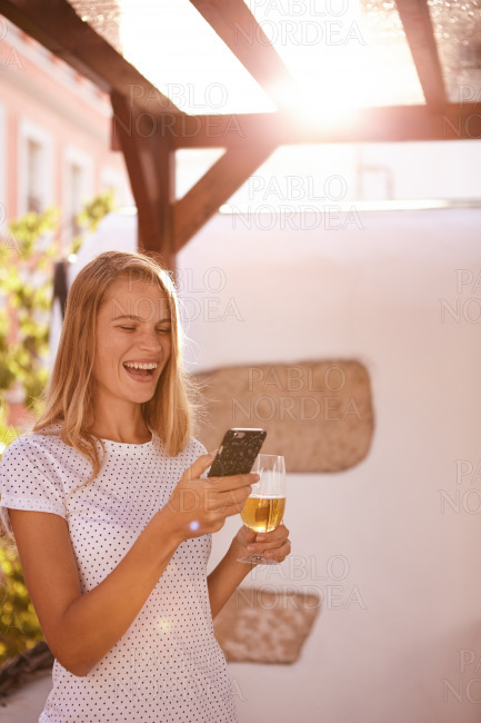 Merrily laughing blond with cellphone and beer