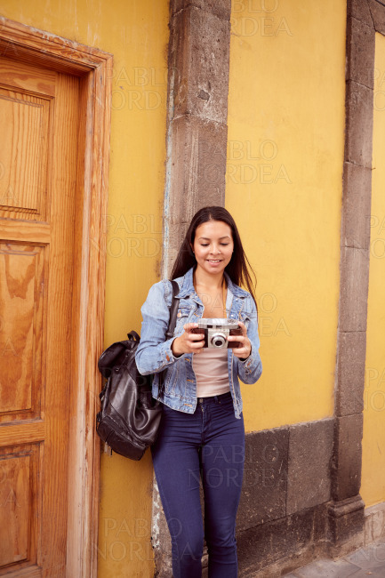 Pretty young girl leaning against a grey pillar stock photo