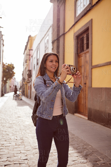 Pretty young girl taking a picture with a camera