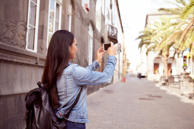 Pretty young girl taking pictures with cell phone