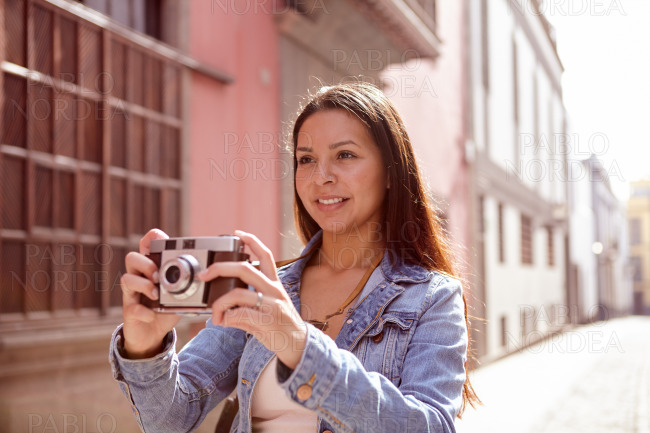 Pretty young girl with a camera looking ahead