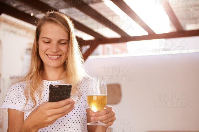 Smiling blond with a cellphone and beer