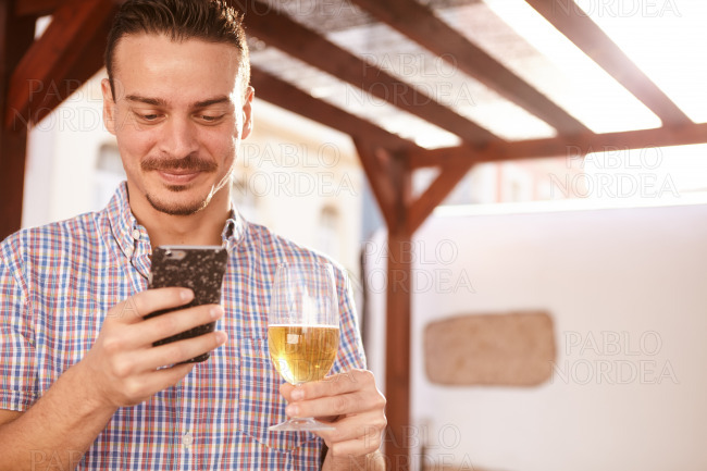 Smiling man with beer and cellphone