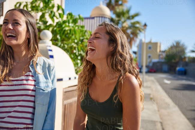 Two beautiful young girls laughing uncontrollably