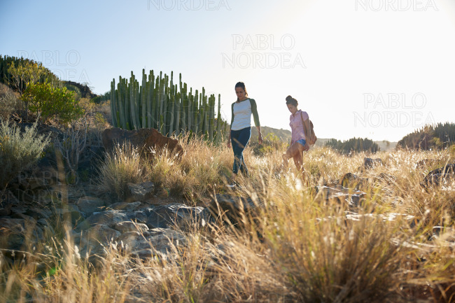 Two girls walking a rocky hillside