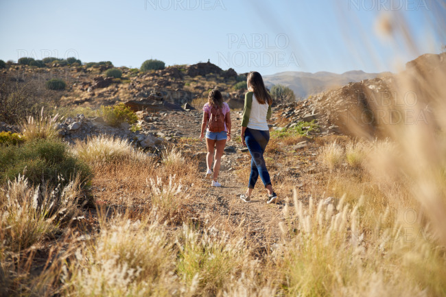 Two young girls strolling up hillside