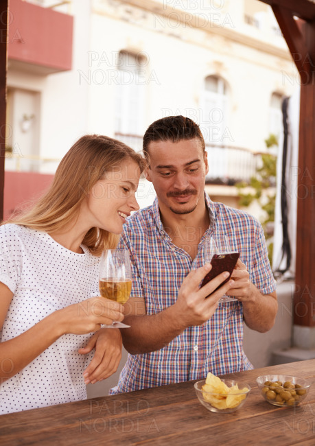 Young couple with beers and cellphone
